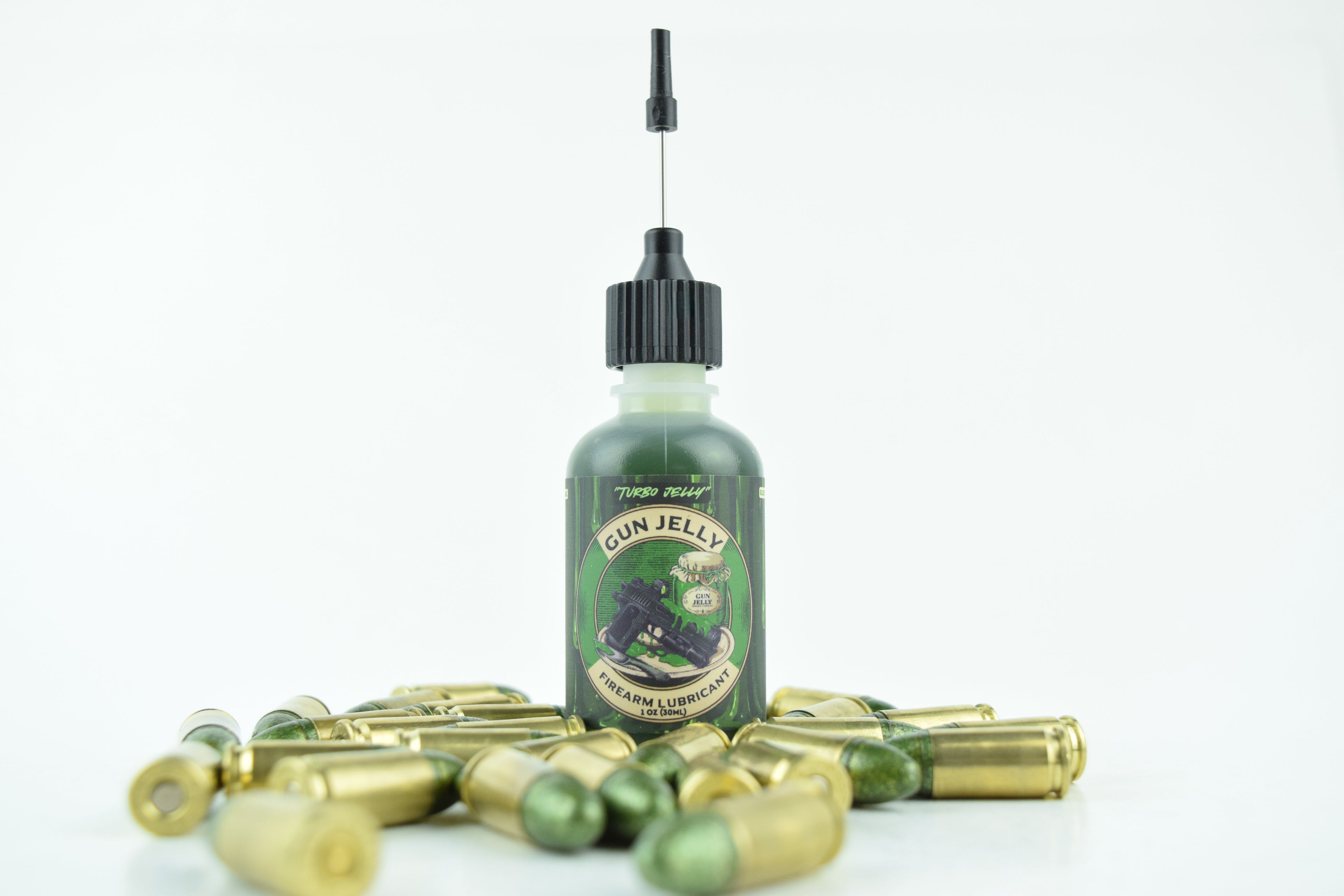 A small bottle of Gun Jelly with a black cap and applicator, surrounded by scattered  green bullets and casings on a white background.