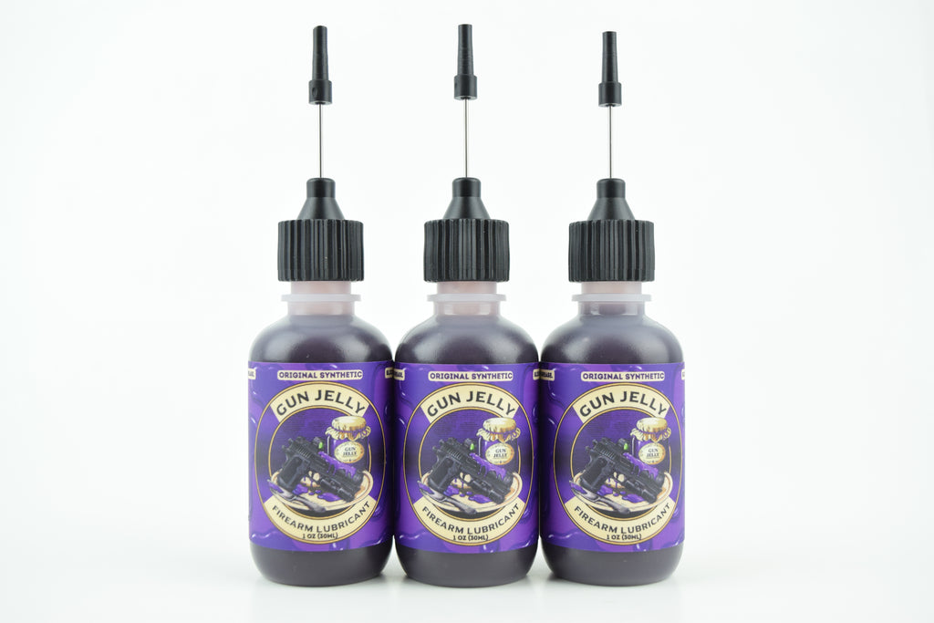 Three bottles of Gun Jelly with purple labels and black applicator caps, arranged side by side on a white background.